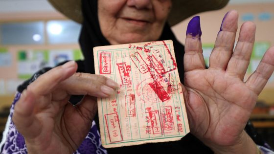 An Algerian woman displays her ink stained finger and card after voting at a polling station during the presidential election, in Algiers on September 7, 2024. About 24 million Algerians are poised to head to the polls September 7 for a vote in which experts say incumbent President Abdelmadjid Tebboune faces no real risk to his tenure as he seeks a second term. (Photo by AFP)
