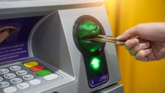 Woman hand is inserting card to atm machine to withdraw or transfer money
