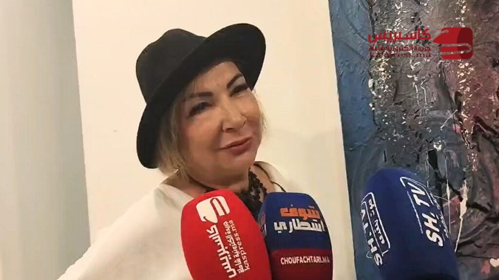 سميرة أنور فنانة تشكيلية مغربية أمام إحدى لوحاتها التجريدية بالدار البيضاء